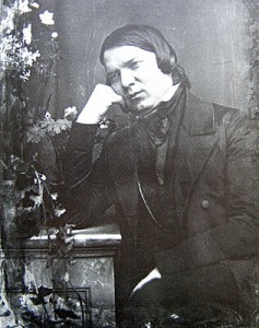 Robert Schumann (1810 - 1856) in seinem 40. Lebensjahr Daguerreotypie von Johann Anton Völlner, Hamburg, März 1850 Robert-Schumann-Haus Zwickau Eine der zwei Daguerreotypien, die Johann Anton Völlner von Robert Schumann allein angefertigt hat. Auch auf der anderen Aufnahme sitzt Robert Schumann auf einem Stuhl im Atelier des Fotografen, verschränkt allerdings die Hände über der Brust. Die hier gezeigte Aufnahme mit dem typischen Melancholiegestus des auf die Hand gestützten Kopfes wurde die Vorlage für die berühmte Kohlezeichnung von Eduard Bendemann aus dem Jahre 1859, die dieser drei Jahre nach dem Tod von Robert Schumann als Pendant zu einer Kohlezeichnung von Clara Schumann anfertigte. (I.B)