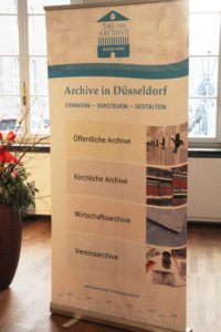 Roll-Up zur Vorstellung der Veranstaltung mit Aufzählung der Archiv-Gruppen