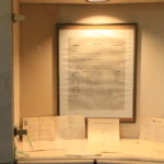 Vitrine mit dem Gründungsplakat und dem originalen Vertrag des Musikers Louis Kreutzer aus dem Jahre 1865.