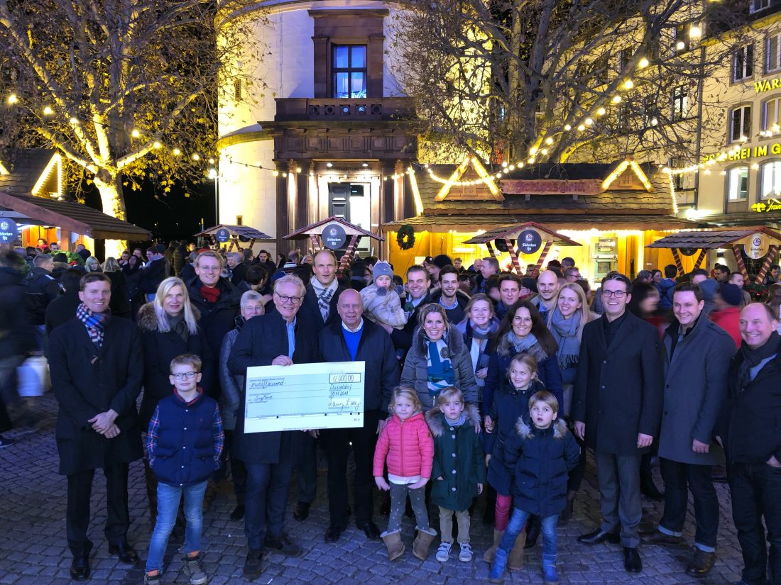 Schecküberreichung auf dem Düsseldorfer Weihnachtsmarkt mit den Mitarbeiter*innen der für die SingPause spendenden Anwaltskanzlei „ROTTHEGE | WASSERMANN“