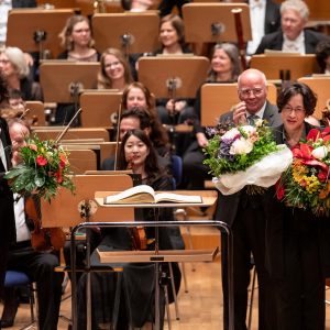 Abschied von Marieddy Rossetto auf dem Podium der Tonhalle Düsseldorf nach dem Konzert vom 3.6.2019. Bild: Alexandre Bloch mit Marieddy Rossetto. Musikvereinsvorsitzender Manfred Hill nach der Blumenübergabe und die Düsseldorfer Symphoniker im Hintergrund - Danke ! Marieddy Rossetto (Foto: Susanne Diesner)