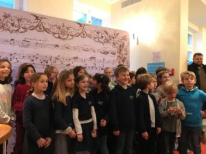 Eröffnung Schumann-Haus: SingPause-Kinder der Klasssen 2,3 und 4 mit ihrer Singleiterin Maria Carreras im Palais Wittgenstein vor der Notenwand nach dem Konzert