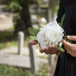 Trauerbild Weiße Rose in der Hand