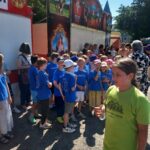 Kinder der Ferdinand-Heye-Schule und der GGS Knittkuhl warten im heißen Sonnenlicht auf ihren Auftritt
