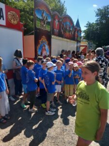 Kinder der Ferdinand-Heye-Schule und der GGS Knittkuhl warten im heißen Sonnenlicht auf ihren Auftritt