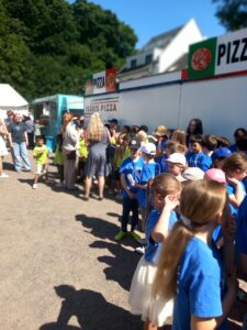 Kinder der Ferdinand-Heye-Schule und der GGS Knittkuhl warten im heißen Sonnenlicht auf ihren Auftritt