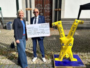 5.9.2026 - Traditionelles großes Straßenfest der Bürgerhilfe Gerresheim auf dem Gerricus-Platz: Bürgermeisterin Clara Gerlach nimmt einen großzügigen Spendenscheck der Ursula Rahmann Stiftung für die Bürgerhilfe Gerresheim entgegen